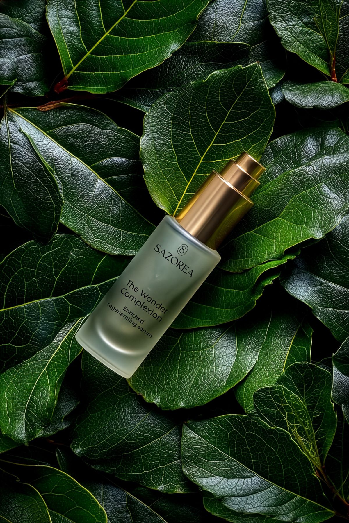 Frasco do sérum Sazorea The Wonder Complexion sobre folhas verdes vibrantes, design de embalagem para cosmética natural dos Açores